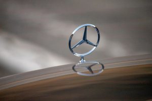 A closeup of the Mercedes-Benz hood ornament on a car hood